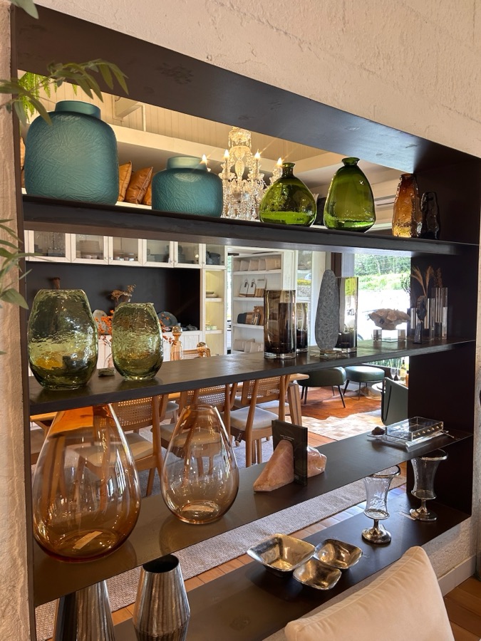 Prateleira com vasos de vidro e objetos decorativos da Naturale Casa & Decor